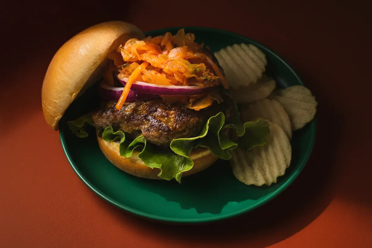 A juicy beef double umami burger with crispy lettuce red onion and shredded orange coleslaw in golden buns