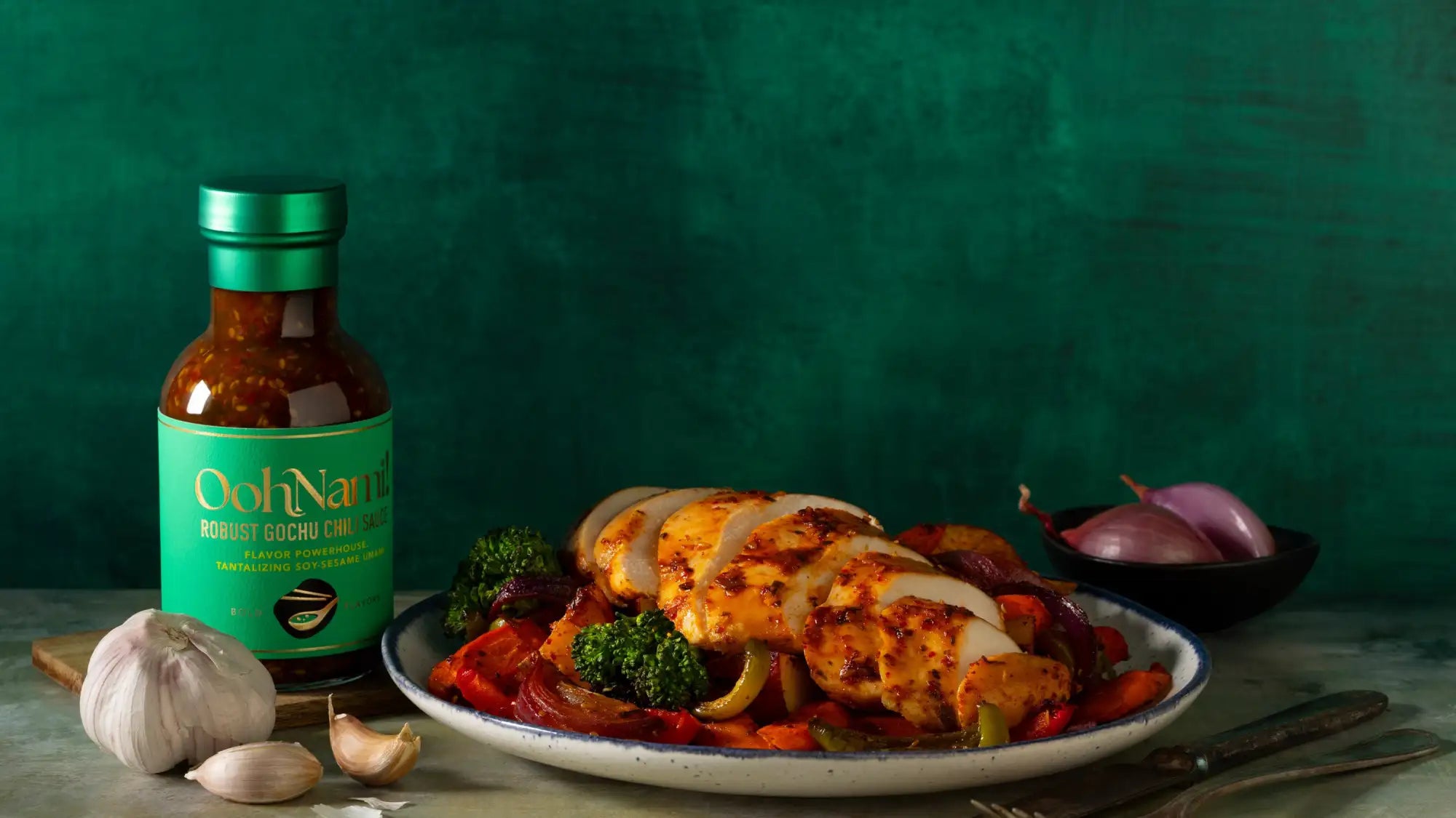 A bottle of ooh nami robust gochu cumin sauce with a green label and metallic cap, filled with rich brown sauce.