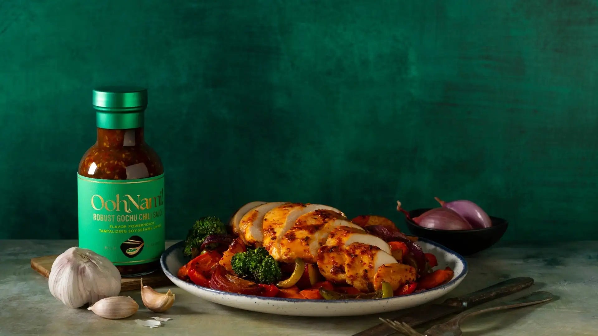 A bottle of ooh nani robust gochu chi sauce with a green label and metallic cap, filled with a rich red sauce.