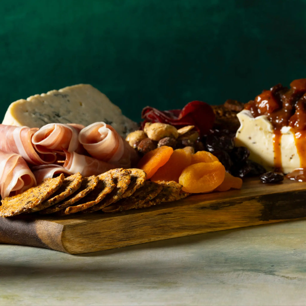 Wooden serving board with rustic natural grain and darkened edge showcasing sweet heat mustard sauce bottle