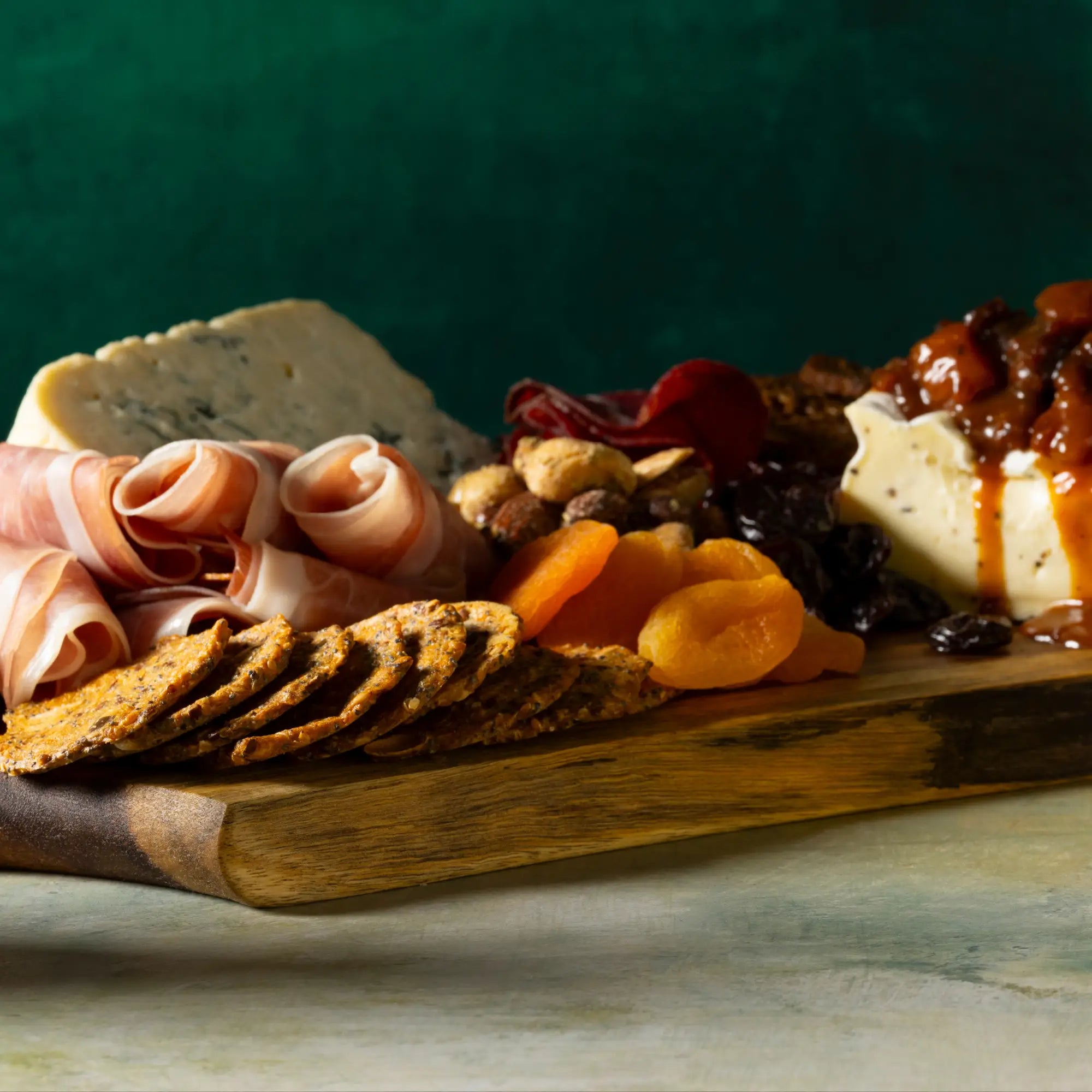 Wooden serving board with rustic natural grain and darkened edge showcasing sweet heat mustard sauce bottle